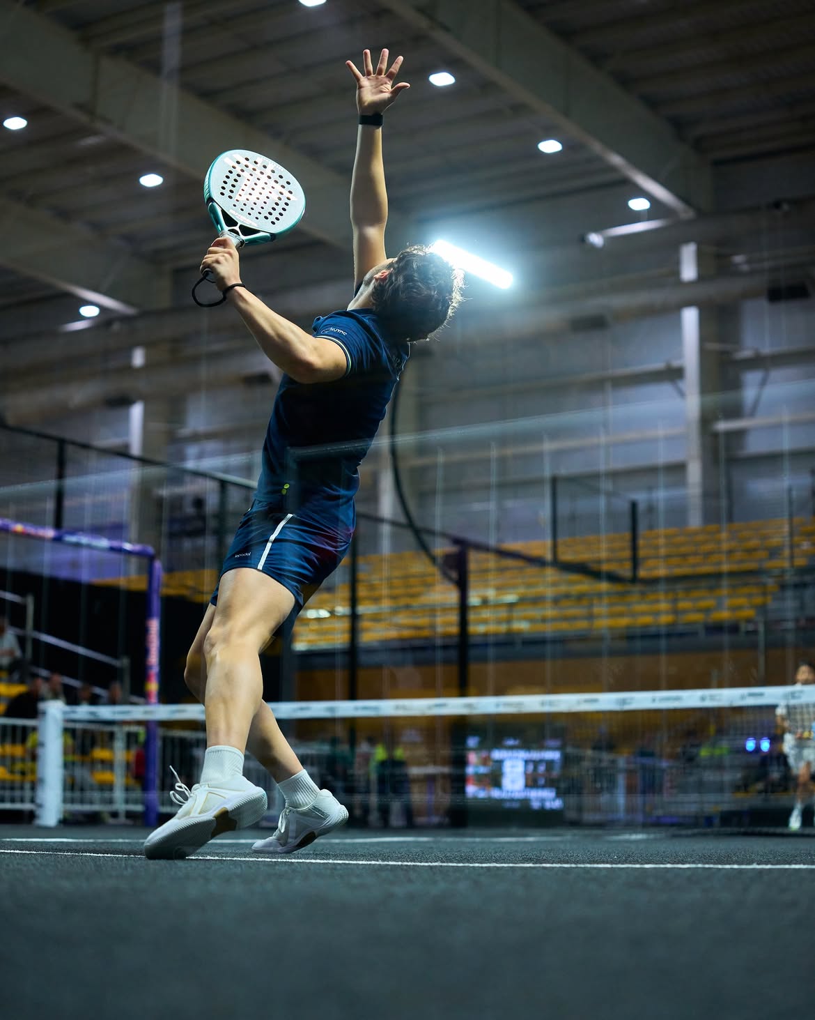 Padel player reflected in the court glass